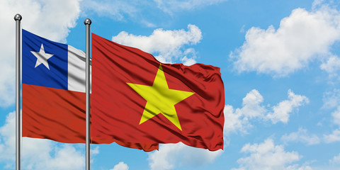 Chile and Vietnam flag waving in the wind against white cloudy blue sky together. Diplomacy concept, international relations.