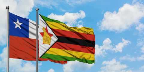 Chile and Zimbabwe flag waving in the wind against white cloudy blue sky together. Diplomacy concept, international relations.