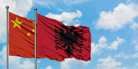 China and Albania flag waving in the wind against white cloudy blue sky together. Diplomacy concept, international relations.