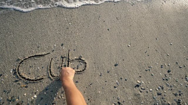 Cuba beach, letters on the sand washed by wave