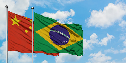 China and Brazil flag waving in the wind against white cloudy blue sky together. Diplomacy concept,...