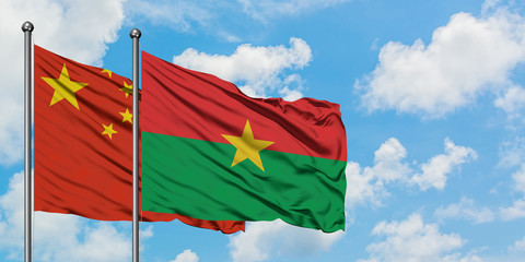 China and Burkina Faso flag waving in the wind against white cloudy blue sky together. Diplomacy concept, international relations.