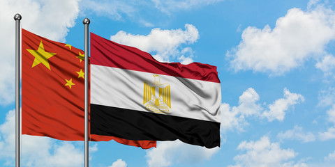 China and Egypt flag waving in the wind against white cloudy blue sky together. Diplomacy concept, international relations.
