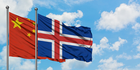 China and Iceland flag waving in the wind against white cloudy blue sky together. Diplomacy...