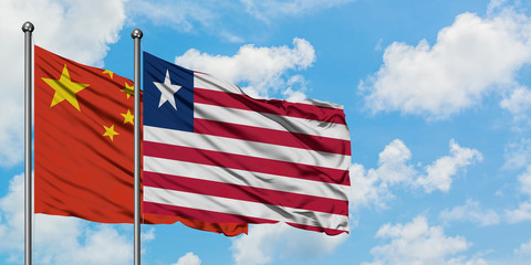China and Liberia flag waving in the wind against white cloudy blue sky together. Diplomacy concept, international relations.