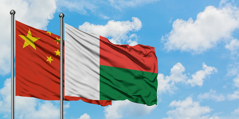 China and Madagascar flag waving in the wind against white cloudy blue sky together. Diplomacy concept, international relations.