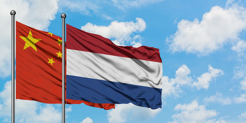 China and Netherlands flag waving in the wind against white cloudy blue sky together. Diplomacy concept, international relations.