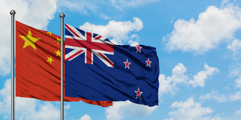 China and New Zealand flag waving in the wind against white cloudy blue sky together. Diplomacy concept, international relations.