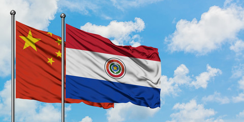 China and Paraguay flag waving in the wind against white cloudy blue sky together. Diplomacy concept, international relations.