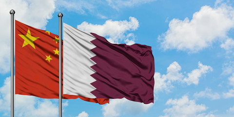 China and Qatar flag waving in the wind against white cloudy blue sky together. Diplomacy concept,...