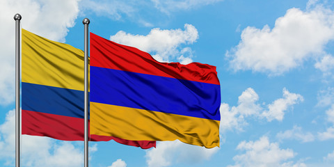 Colombia and Armenia flag waving in the wind against white cloudy blue sky together. Diplomacy concept, international relations.