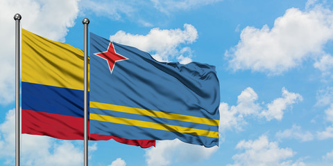 Colombia and Aruba flag waving in the wind against white cloudy blue sky together. Diplomacy concept, international relations.