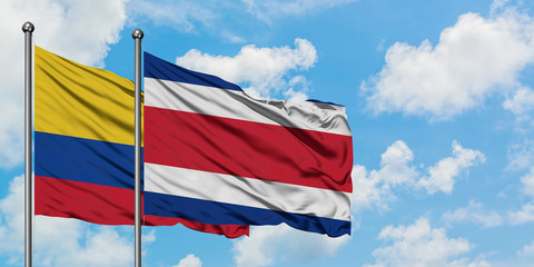 Colombia and Costa Rica flag waving in the wind against white cloudy blue sky together. Diplomacy concept, international relations.