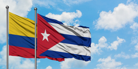 Colombia and Cuba flag waving in the wind against white cloudy blue sky together. Diplomacy concept, international relations.