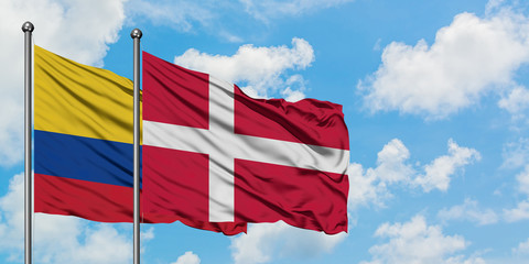 Colombia and Denmark flag waving in the wind against white cloudy blue sky together. Diplomacy concept, international relations.