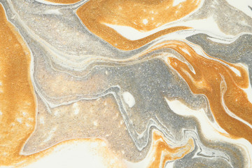 Layers of metallic gold and silver flow gently downwards in this abstract background.