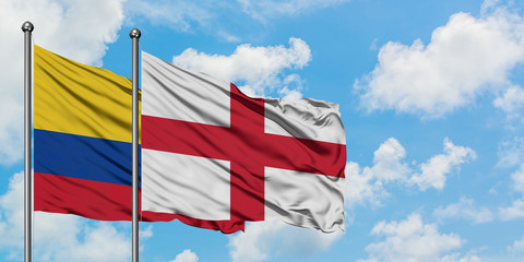 Colombia and England flag waving in the wind against white cloudy blue sky together. Diplomacy concept, international relations.