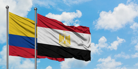 Colombia and Egypt flag waving in the wind against white cloudy blue sky together. Diplomacy concept, international relations.