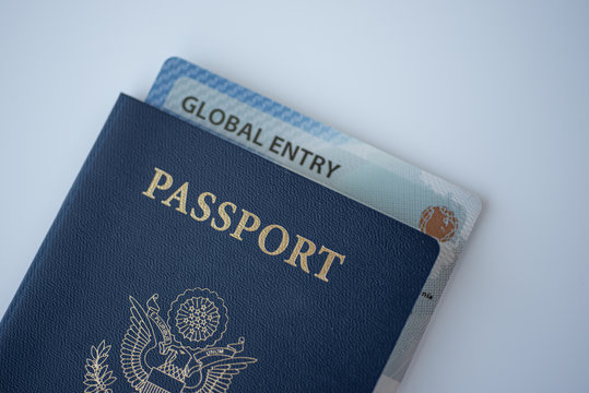 Global Entry Card (Trusted Traveller) Covered Of Passport Of United States On White Background.