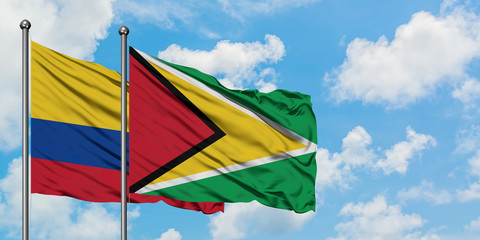 Colombia and Guyana flag waving in the wind against white cloudy blue sky together. Diplomacy concept, international relations.