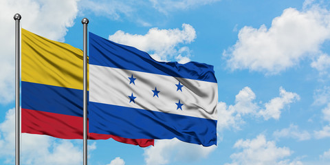 Colombia and Honduras flag waving in the wind against white cloudy blue sky together. Diplomacy concept, international relations.