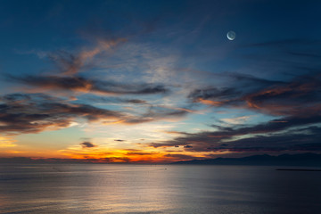 月と暁に染まる海と雲