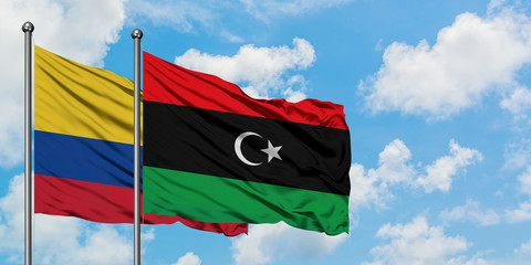 Colombia and Libya flag waving in the wind against white cloudy blue sky together. Diplomacy concept, international relations.