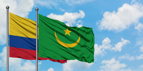 Colombia and Mauritania flag waving in the wind against white cloudy blue sky together. Diplomacy concept, international relations.