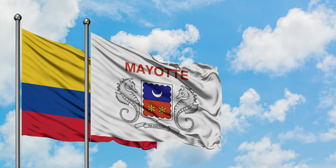 Colombia and Mayotte flag waving in the wind against white cloudy blue sky together. Diplomacy...