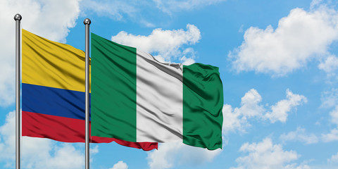 Colombia and Nigeria flag waving in the wind against white cloudy blue sky together. Diplomacy concept, international relations.