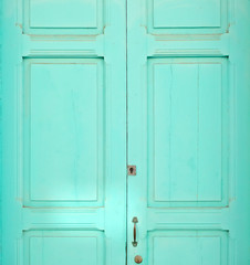 Plain wooden door painted pastel turquoise color.