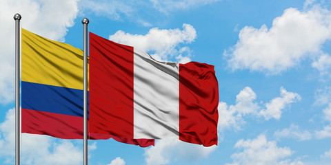 Colombia and Peru flag waving in the wind against white cloudy blue sky together. Diplomacy concept, international relations.