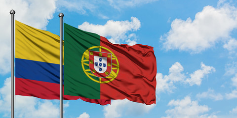 Colombia and Portugal flag waving in the wind against white cloudy blue sky together. Diplomacy concept, international relations.