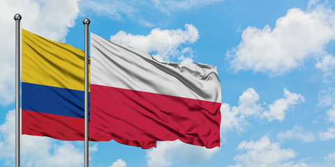 Colombia and Poland flag waving in the wind against white cloudy blue sky together. Diplomacy concept, international relations.