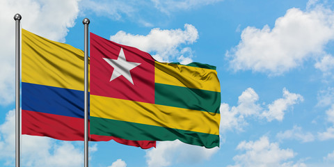 Colombia and Togo flag waving in the wind against white cloudy blue sky together. Diplomacy concept, international relations.