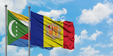 Comoros and Andorra flag waving in the wind against white cloudy blue sky together. Diplomacy concept, international relations.