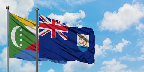 Comoros and Anguilla flag waving in the wind against white cloudy blue sky together. Diplomacy...
