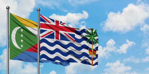 Comoros and British Indian Ocean Territory flag waving in the wind against white cloudy blue sky...