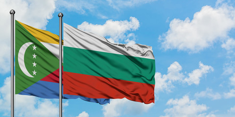 Comoros and Bulgaria flag waving in the wind against white cloudy blue sky together. Diplomacy concept, international relations.