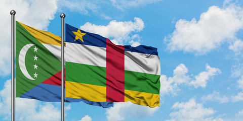 Comoros and Central African Republic flag waving in the wind against white cloudy blue sky...