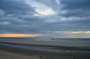 A dark stormy cumulonimbus cloudy coastal ocean sunrise seascape. Huay Yang,Thailand.
