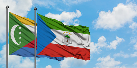 Comoros and Equatorial Guinea flag waving in the wind against white cloudy blue sky together. Diplomacy concept, international relations.