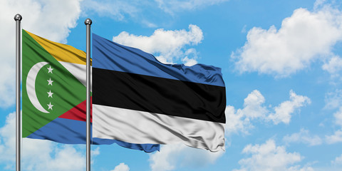 Comoros and Estonia flag waving in the wind against white cloudy blue sky together. Diplomacy concept, international relations.