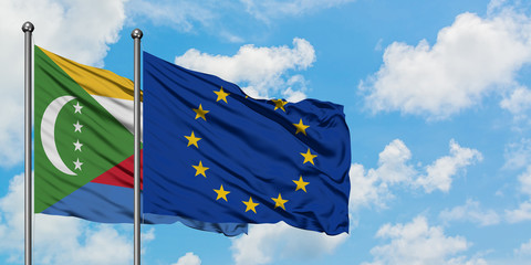 Comoros and European Union flag waving in the wind against white cloudy blue sky together. Diplomacy concept, international relations.