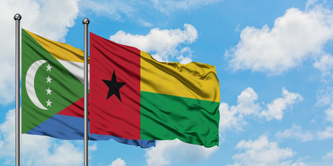 Comoros and Guinea Bissau flag waving in the wind against white cloudy blue sky together. Diplomacy concept, international relations.