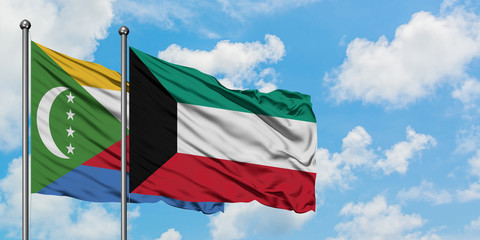 Comoros and Kuwait flag waving in the wind against white cloudy blue sky together. Diplomacy concept, international relations.