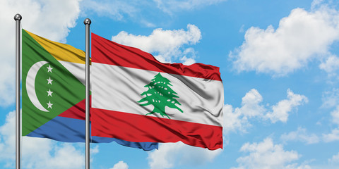 Comoros and Lebanon flag waving in the wind against white cloudy blue sky together. Diplomacy concept, international relations.