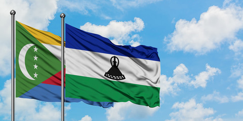 Comoros and Lesotho flag waving in the wind against white cloudy blue sky together. Diplomacy concept, international relations.