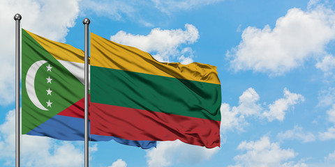 Comoros and Lithuania flag waving in the wind against white cloudy blue sky together. Diplomacy concept, international relations.