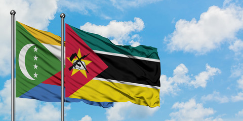 Comoros and Mozambique flag waving in the wind against white cloudy blue sky together. Diplomacy concept, international relations.